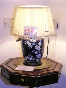 Dark blue jar lamp with white blossom including round pleated shade