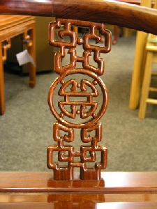 close up view of openwork longevity carving on rosewood corner chair